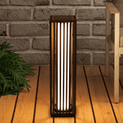 תאורת גינה סולארית דולקת המפיקה אור חמים ליד קיר לבנים