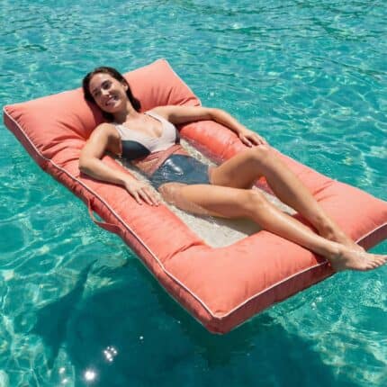 אישה בבגד ים כהה נחה על פוף צף קורל Relax בלב מי טורקיז צלולים